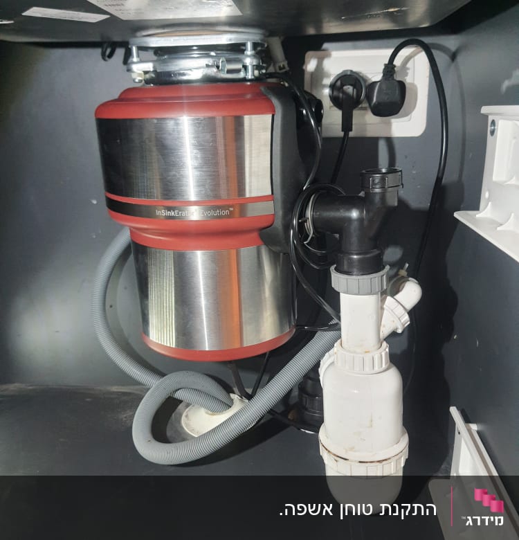 מטחנת אשפה מתחת לכיור עם צינורות חיבור